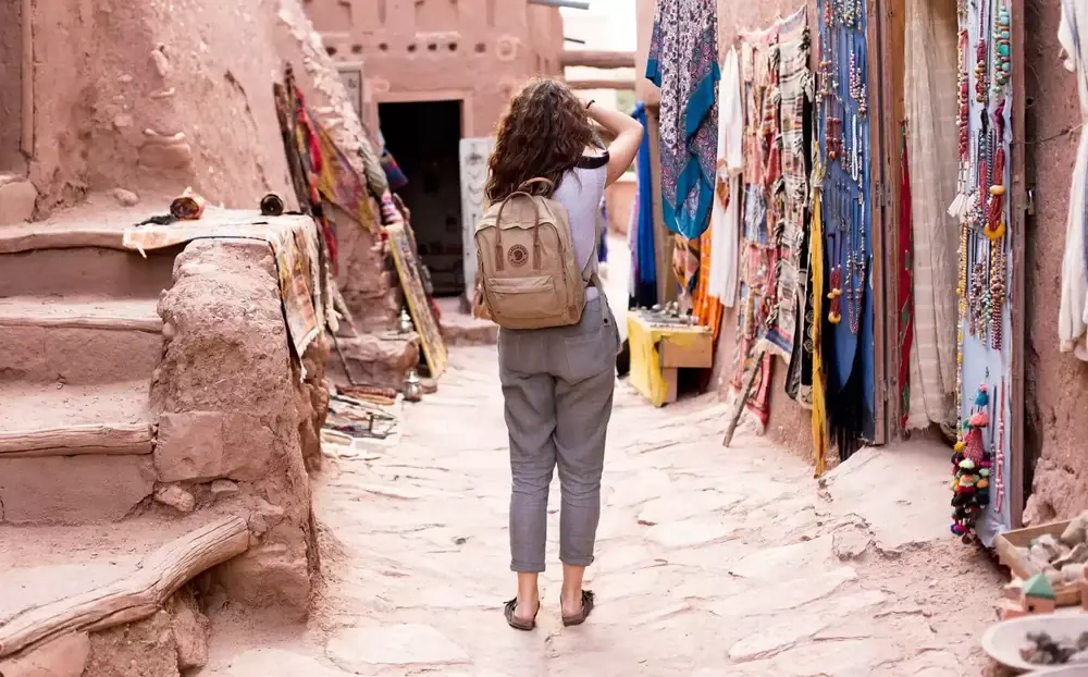 A traveller walking up a lane of craft stalls inside the Ait Ben Haddou ksar