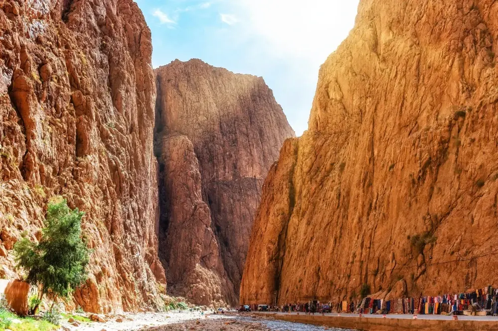 The red rock walls of Todra Gorge with walkers at the bottom